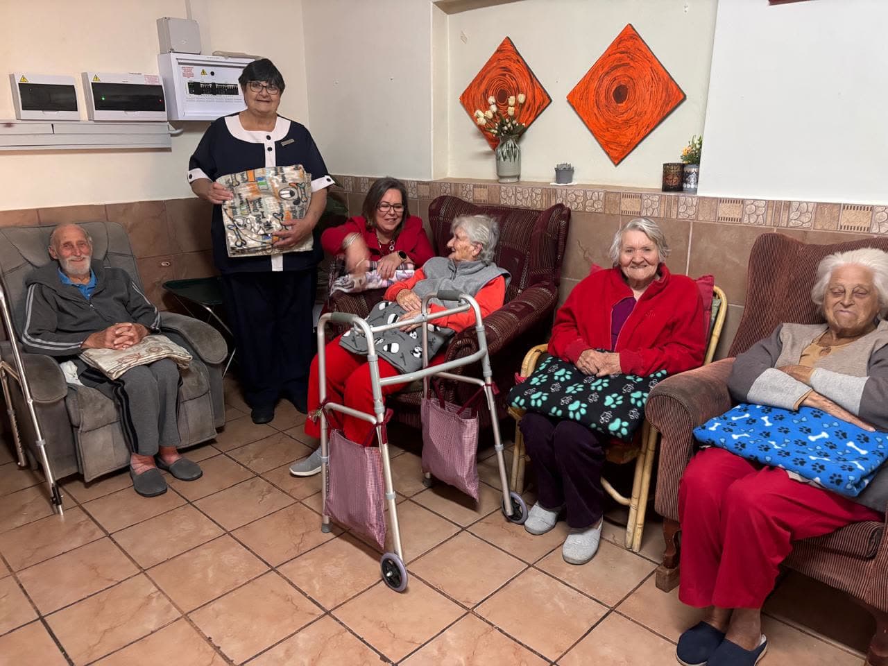 Residents of Avondrus Frail Care Centre with their new blankets in the lounge